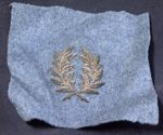 Décoration représentant deux feuilles de laurier entrelacées, cousues sur de la feutrine bleue